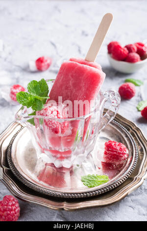 Hausgemachter Himbeer Eis am Stiel im Glas mit Eis, Himbeeren und Minze. Sommer-gesund-Food-Konzept. Stockfoto