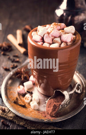 Tasse heiße Schokolade mit Mini Marshmallows und Winter Gewürze auf dunklem Holz. Stockfoto