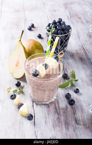 Heidelbeeren und Birne Smoothie in einem Glas auf einem rustikalen Tisch. Gesunde Ernährung-Konzept. Stockfoto
