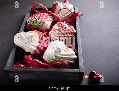 Hausgemachte Meringues in Herzform in alten Holzkiste zum Valentinstag. Stockfoto