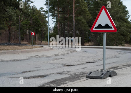 Schuss der Schlaglöcher auf der Straße mit Schild Stockfoto