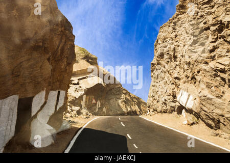 Schön geschwungene Straße durch einsame Felsen und Berge zwischen Ajmer und Pushkar, Rajasthan, Indien Stockfoto