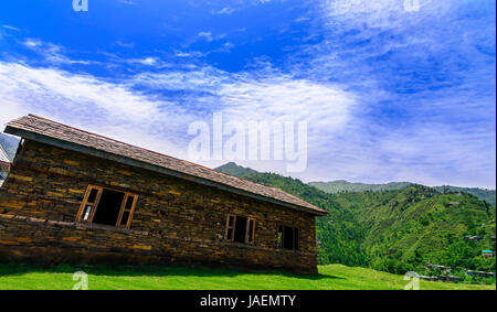 Idyllische und wunderschöne Landschaft mit einem alten verlassenen Holzhaus im Janjehli-Tal, Himachal Pradesh Stockfoto