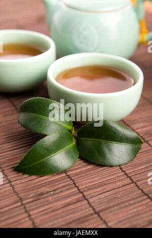 Eine Tasse grüner Tee mit mittelgewichtig Blätter Stockfoto