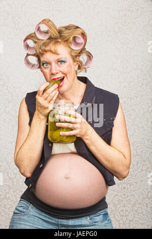 Einzelne junge Schwangere in Lockenwickler und jeans Stockfoto