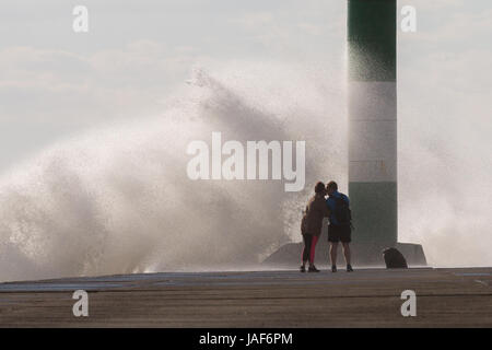 Ein paar Gehminuten entlang der konkreten Bootsanleger und einen schnellen Kuss haben, sobald Sie das Ende erreicht, während die starken Winde mit einer rauhen Meer Wellen über den Steg zu bringen. Credit: Ian Jones/Alamy leben Nachrichten Stockfoto