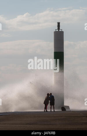 Ein paar Gehminuten entlang der konkreten Bootsanleger und einen schnellen Kuss haben, sobald Sie das Ende erreicht, während die starken Winde mit einer rauhen Meer Wellen über den Steg zu bringen. Credit: Ian Jones/Alamy leben Nachrichten Stockfoto