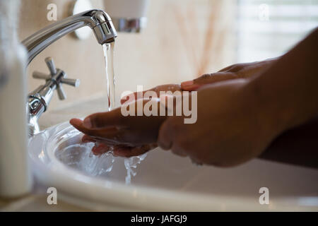 Bild von Menschen Händewaschen im Waschbecken im Badezimmer zu Hause abgeschnitten Stockfoto