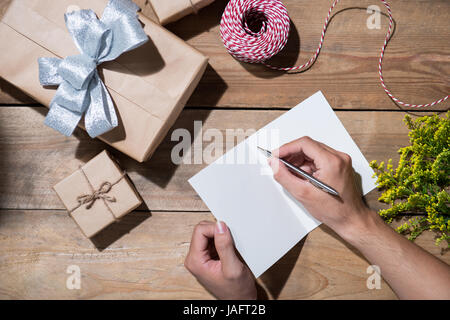Handschrift mit Geburtstagsgeschenk auf hölzernen Hintergrund wünschen. Ansicht von oben Stockfoto
