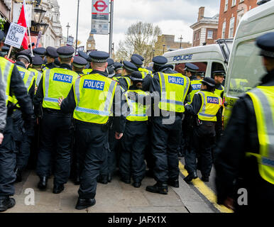 Die Polizisten der Großstädte treffen mit Anhängern der Unite Gegen die Faschismusbewegung, die gegen eine EDL-Kundgebung im Zentrum Londons, Großbritannien, protestieren. Stockfoto