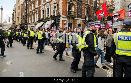 Die Polizisten der Metropole begleiten Anhänger der Bewegung "Unite Against Fascism", die gegen eine EDL-Kundgebung im Zentrum von London, Großbritannien demonstrieren. Stockfoto