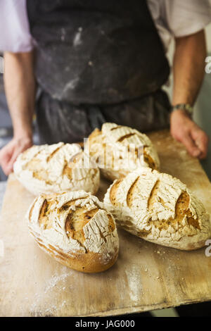 Baker Holding Tablett mit frisch gebackenen Brote Stockfoto