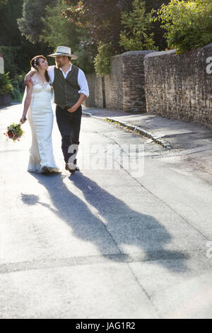 Braut und Bräutigam auf einer ländlichen Straße. Stockfoto