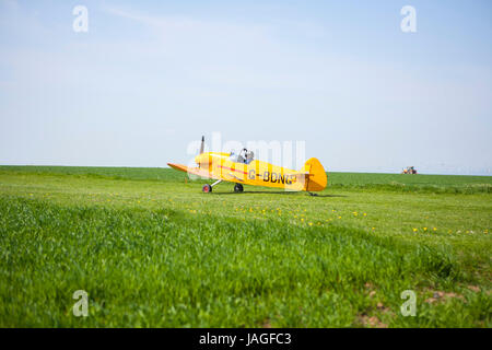 sehr kleine gelbe Flugzeuge Rollen entlang rural Feld bereit zum abheben für Flug Stockfoto