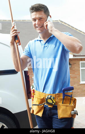 Klempner mit Van telefonieren mit Handy vor Haus Stockfoto