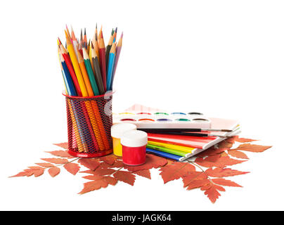 Ausstattung der Schule mit Stiften, Farben, Pinsel und Herbstlaub isoliert auf weiss.  Zurück zum Schulkonzept. Schule Schreibwaren Stockfoto