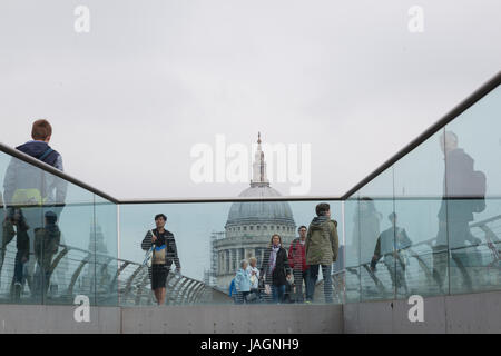 London, Vereinigtes Königreich, am 6. Mai 2017: Menschen überqueren Themse auf Millennium-Brücke mit St. Pauls Kathedrale im Hintergrund an bewölkten Tag in Londo Stockfoto