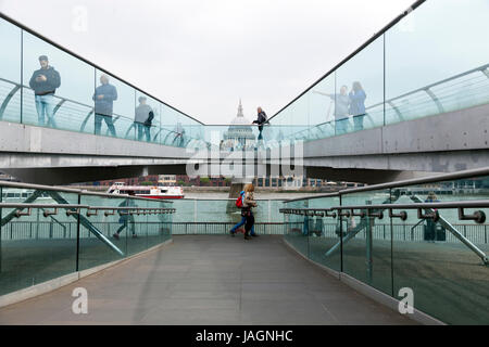 London, Vereinigtes Königreich, am 6. Mai 2017: Menschen überqueren Themse auf Millennium-Brücke mit St. Pauls Kathedrale im Hintergrund an bewölkten Tag in Londo Stockfoto