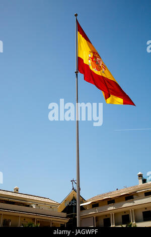 Die spanische Flagge (Bandera de España, umgangssprachlich bekannt als "la Rojigualda") fliegt vor einem tiefblauen Himmel. Stockfoto