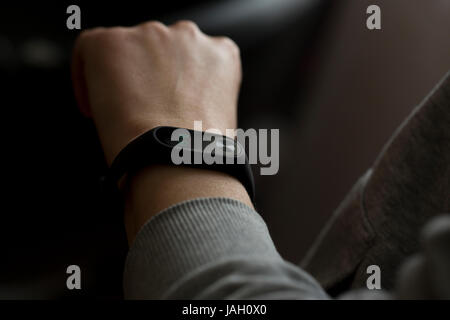 Nahaufnahme der schwarzen Fitness-tracking-Band auf der weiblichen Seite. Stockfoto