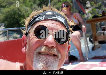 Ein Engländer mit einem Bart trägt ein Kopftuch und coole Sonnenbrillen während des Urlaubs, 2017 Stockfoto