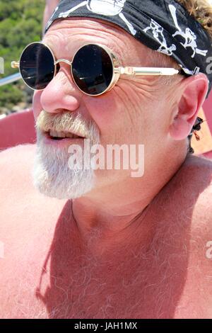 Ein Engländer mit einem Bart trägt ein Kopftuch und coole Sonnenbrillen während des Urlaubs, 2017 Stockfoto