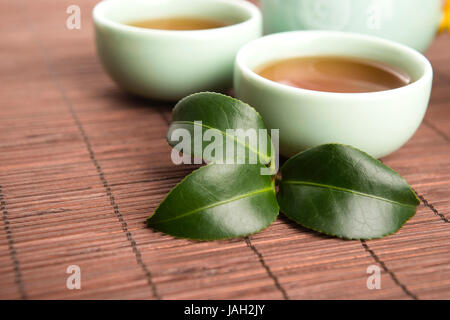 Eine Tasse grüner Tee mit mittelgewichtig Blätter Stockfoto