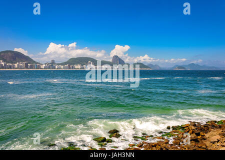 Copacabana Strand in Rio De Janeiro mit seinen Gebäuden, Meer, Sand und den Zuckerhut im Hintergrund Stockfoto