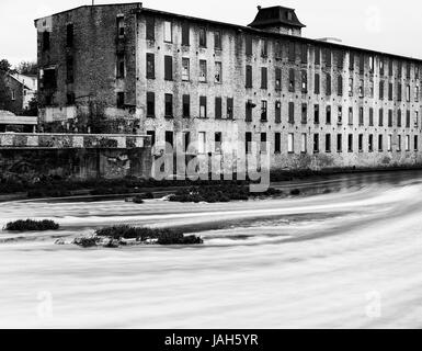 Alte Industriegebäude durch Fluss schwarz / weiß Bild. Stockfoto