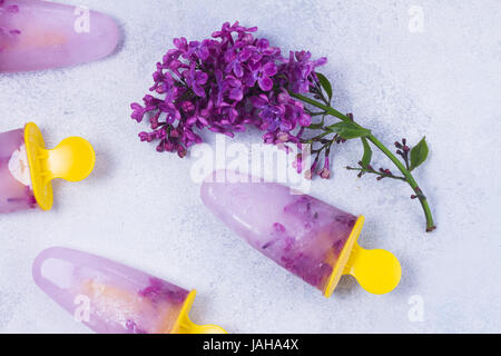 Eis am Stiel mit lila Blumen Stockfoto