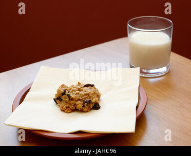 Mit ein Glas kalte Milch serviert frische Haferflocken-Rosinen-Cookies Stockfoto