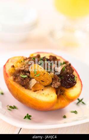 Bohnenkraut gebackene Apfel gefüllt mit Hackfleisch, Rosinen, Sultaninen, Zwiebel und Walnuss, bestreut mit frischer Thymian-Blätter an der Spitze (selektiven Fokus, Fokus auf die Sultana in der Front) Stockfoto