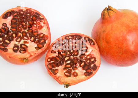 Rote, saftige Samen sichtbar auf Hälfte geschnittene Granatapfel-Frucht, isoliert auf weiss Stockfoto