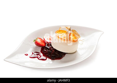 Vanilleeis mit Kompott auf einem weißen Teller serviert, dekoriert mit verschiedenen Früchten und eine Orangenscheibe karamellisieren, weißen Hintergrund Stockfoto