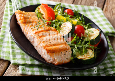 Gesunde Ernährung: Gegrilltes Lachsfilet mit Gemüse, Salat und Rucola Closeup auf dem Tisch. horizontale Stockfoto