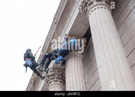 London, Vereinigtes Königreich, am 6. Mai 2017: zwei Arbeiter mit Helmen von Seilen an der klassizistischen Gebäude in London Arbeiten hängen Stockfoto