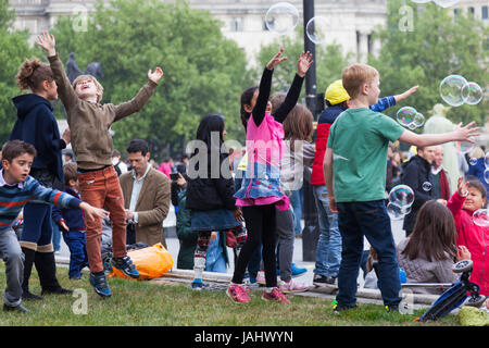 London, Vereinigtes Königreich, am 6. Mai 2017: Kinder haben Spaß mit Riesenseifenblasen am Trafalgar square vor der Nationalgalerie Museum Stockfoto