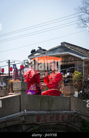 Junges Paar gekleidet in traditionellen Kleidern Posen auf einer Brücke, Men Road, alten District, Suzhou, Provinz Jiangsu, China Stockfoto