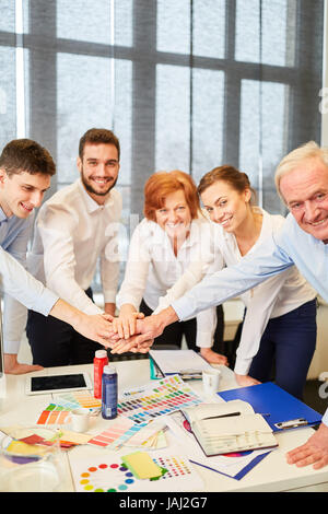 Erfolgreiches Team von Designern Stapeln ihre Hände zusammen mit Freude Stockfoto