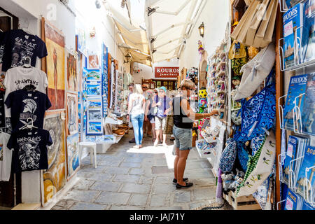 Touristen, die Einkaufsmöglichkeiten für Souvenirs im Dorf Lindos, Rhodos, Griechenland Stockfoto