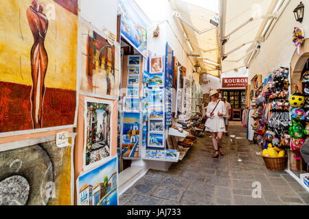 Touristen, die Einkaufsmöglichkeiten für Souvenirs In der Stadt Lindos, Rhodos, Griechenland Stockfoto