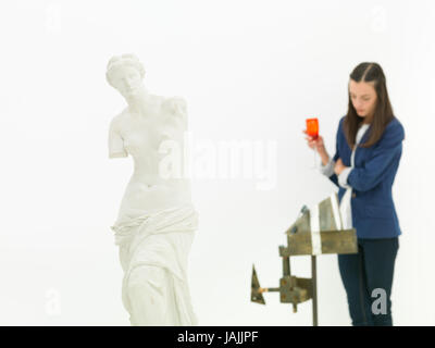 Frau Skulptur hinter eine Replik der Venus von Milo Statue in einem Museum zu hinterfragen Stockfoto