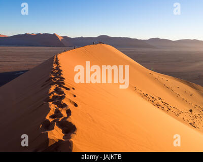 SOUSSUSVLEI, NAMIBIA - 20. Juni 2016: Leute beobachten Sonnenaufgang Form die Düne 45 im Bereich Sossusvlei der Namib-Wüste in Namibia. Stockfoto