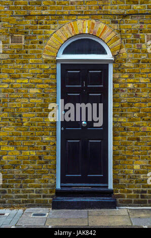 stilvolle Eingang eines Wohnhauses, wölbt sich eine interessante Fassade des alten Steins über der Tür, eine typisch englische Altbauten, london Stockfoto