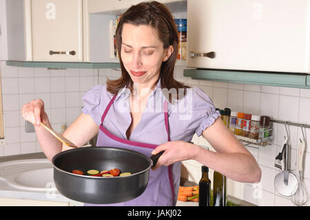 Angetreten Hausfrau Steht in Ihrer Hellen Einbauküche Kocht Frisches Gemüse in Einer Pfanne. Stockfoto