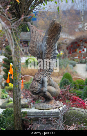 Engelsstatue mit Flügeln im bunten Garten Stockfoto