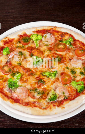 Pizza mit Shrimps und Broccoli am Tisch Stockfoto