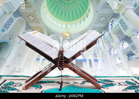 Islamische Buch des Koran offen für rezitieren mit Perlen mit Moschee innen Hintergrund Stockfoto