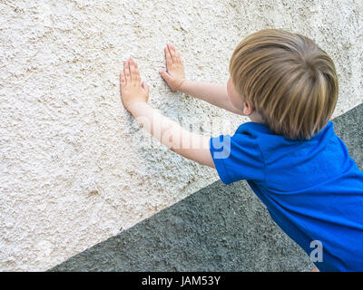 Versteckspiel Spiel. Cute blonde Kind. Beachten Sie die Hände und Wand für größere Anonymität eines jungen im Mittelpunkt. Stockfoto