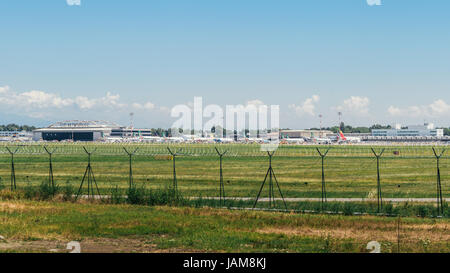 Kommerzielle Flugzeuge am Mailänder Flughafen Linate in Italien an einem schönen Sommertag, wo der italienischen Alpen sichtbar sind Stockfoto